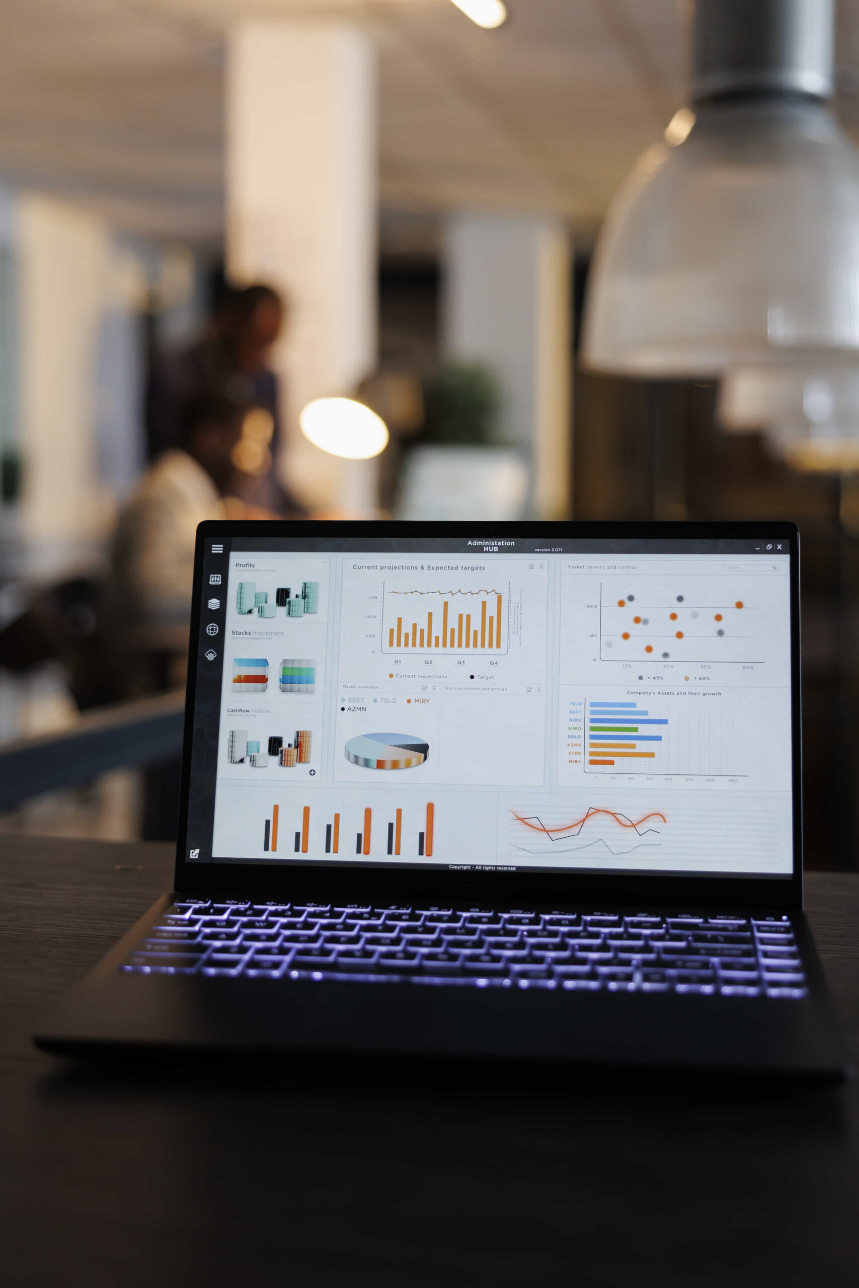 laptop-computer-with-marketing-statistics-graphs-screen-standing-table-startup-office-coworkers-discussing-company-strategy-background-employees-working-overtime-startup-office